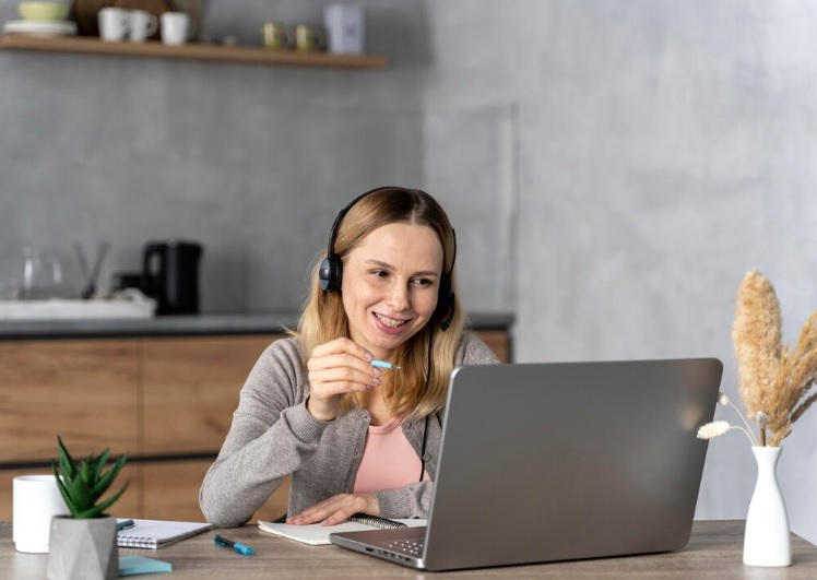 Endocrino em sao paulo - Mulher sorridente falando ao telefone em frente ao computadoe de escritorio